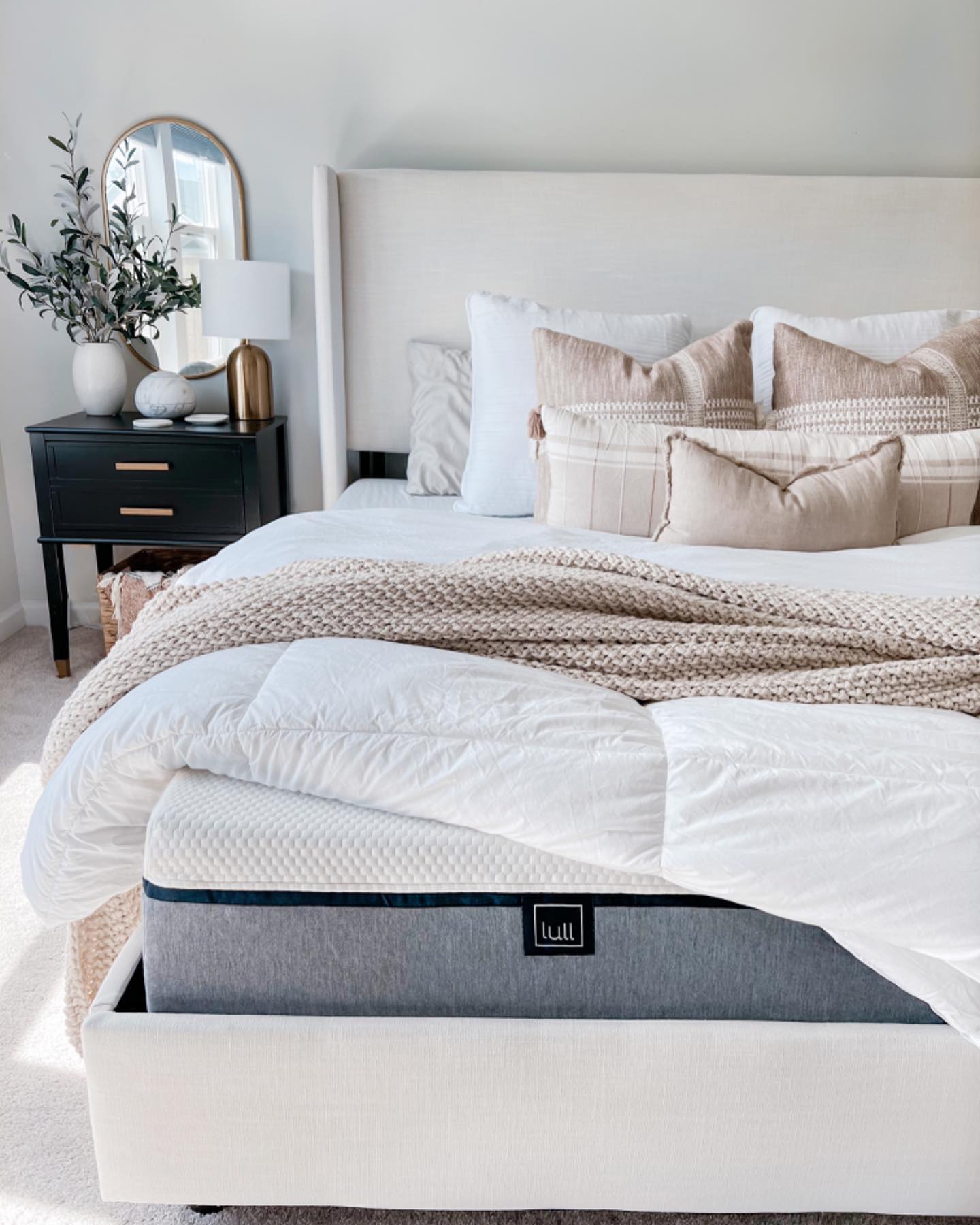 A classy bedroom with a lull mattress and several pillows on top.