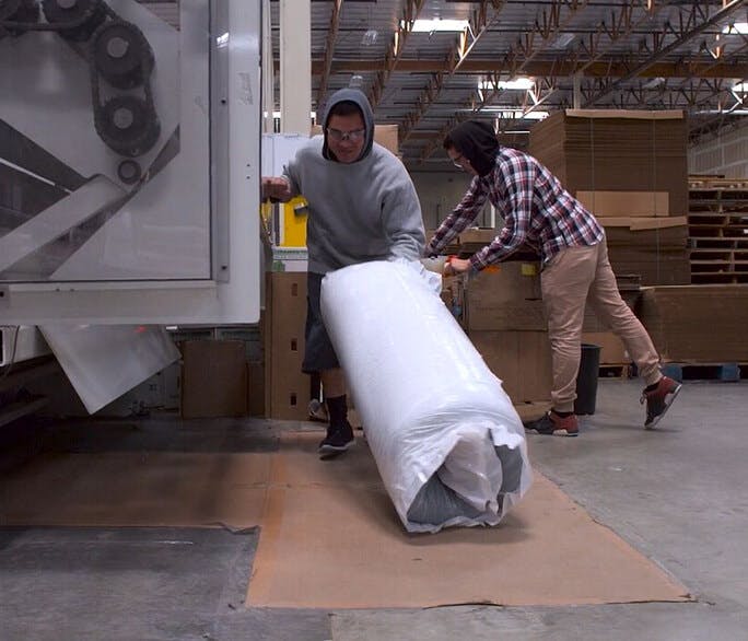 A lull mattress rolled up and ready to be boxed.