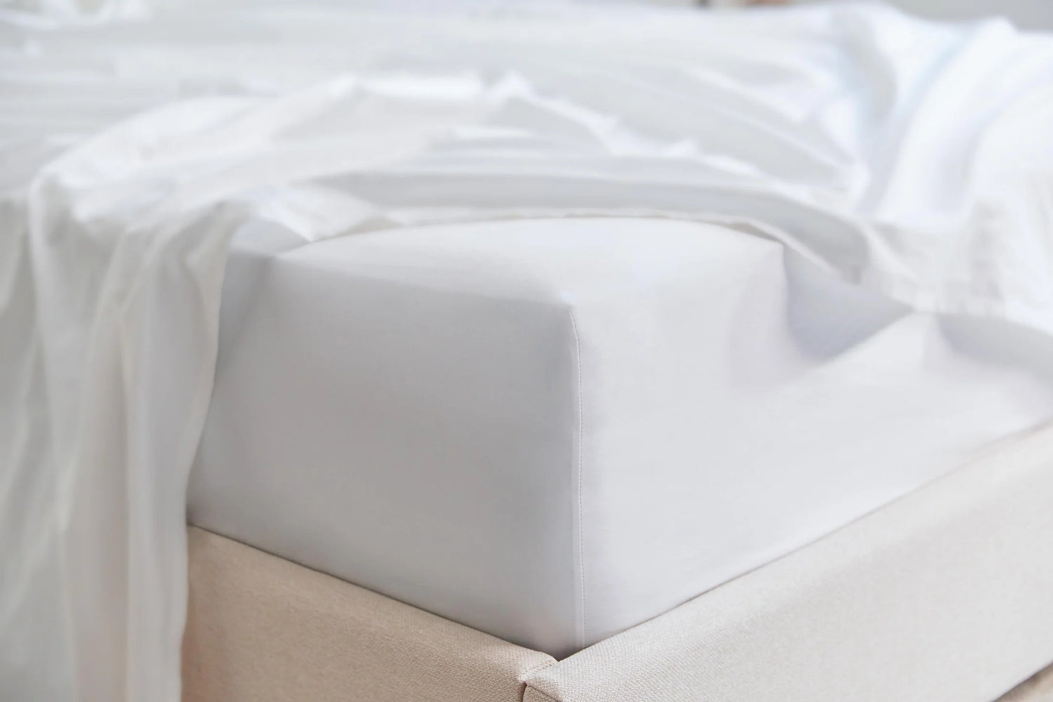 A picture of white sheets on a mattress.