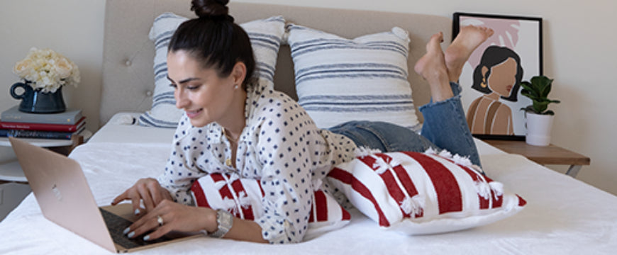 Women laying on bed using laptop