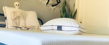 Skeleton laying on Lull bed with Lull pillows