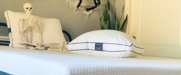 Skeleton laying on Lull bed with Lull pillows