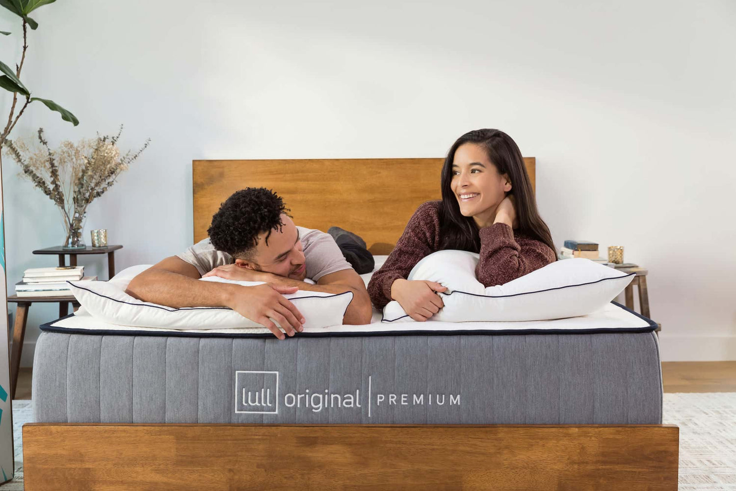 A couple laying comfortably on a lull original premium mattress while smiling at each other.