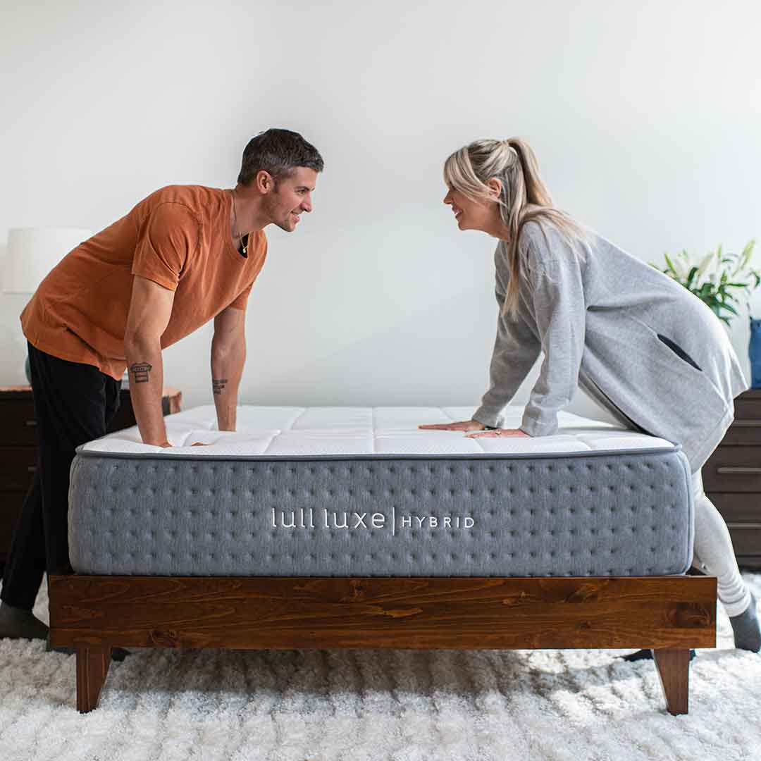 A couple pressing down on a comfy mattress