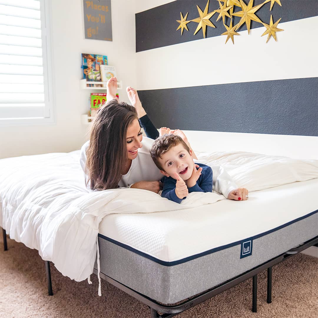 A mother and son laughing on a comfy mattress