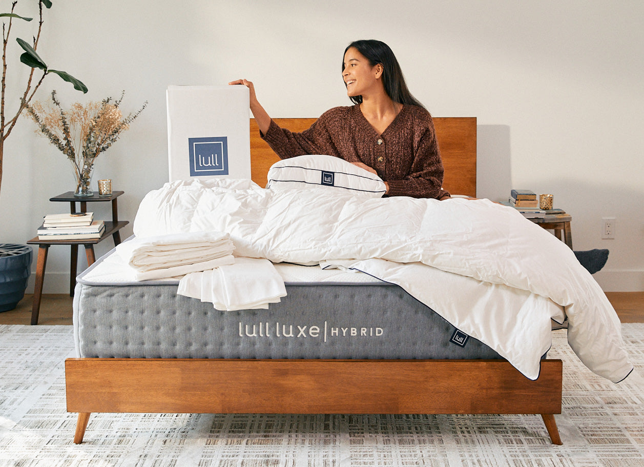 Woman laying on a lull mattress with the lull bedding bundle.