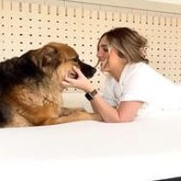A dog and woman embracing on a Lull mattress.