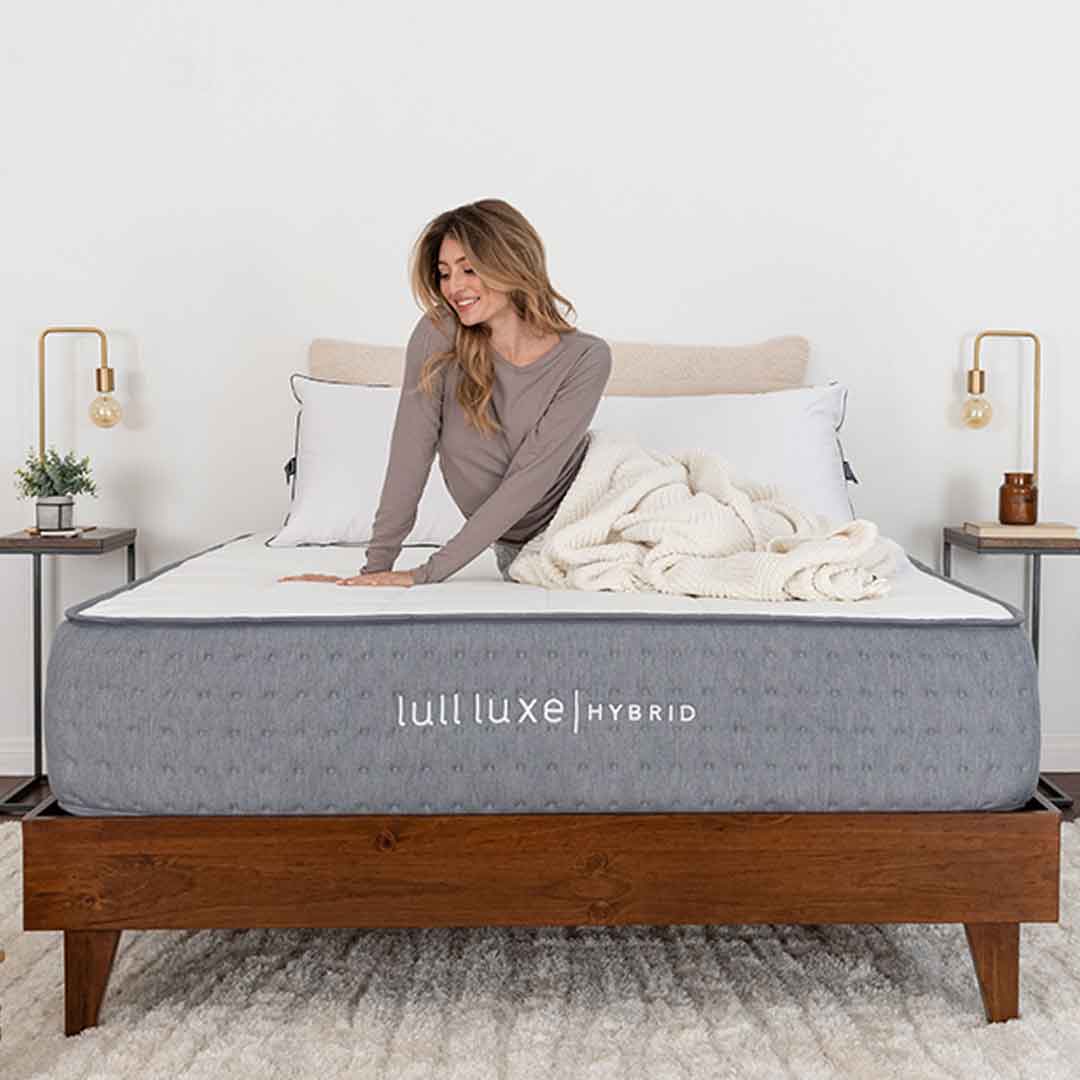 A woman wrapped in a blanket on top of a comfy mattress